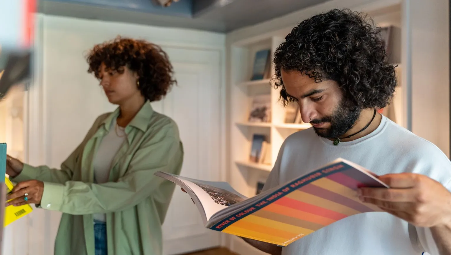 A couple reading books in the museum shop of Huis Marseille.