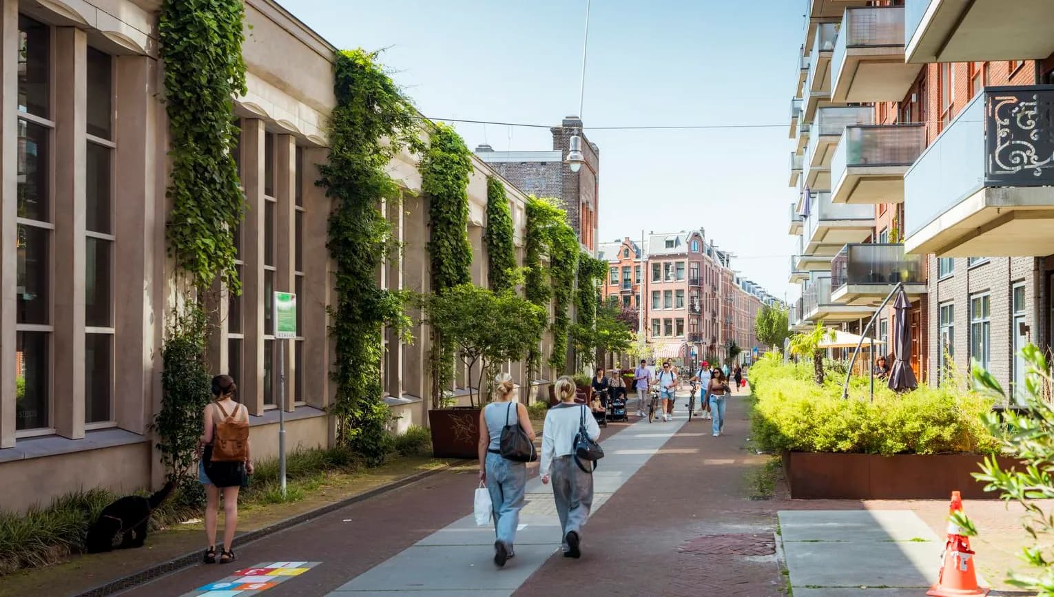 People walking over Hannie Dankbaarpassage next to De Hallen.