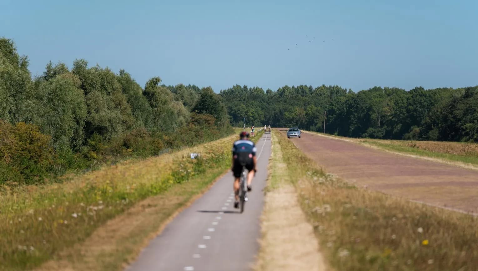 A cyclist on De Knardijk. An inner dike that forms the border between eastern and southern Flevoland as a land divide.
