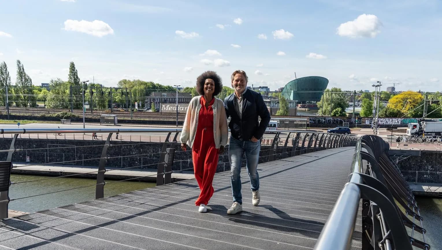 A couple crossing the bridge towards het Muziekgebouw aan 't IJ.
