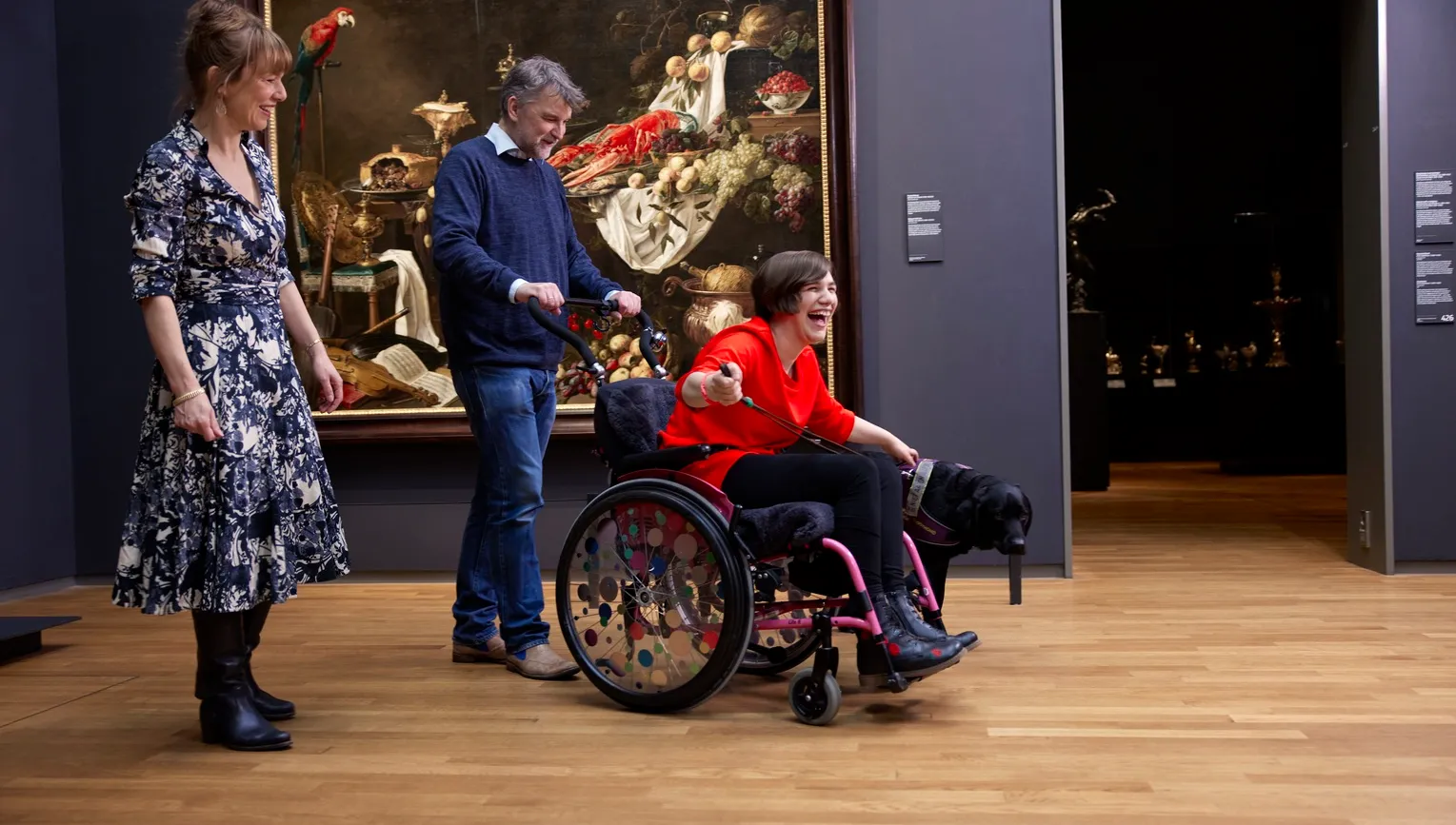 Happy woman in a wheelchair and a dog, visiting Rijksmuseum