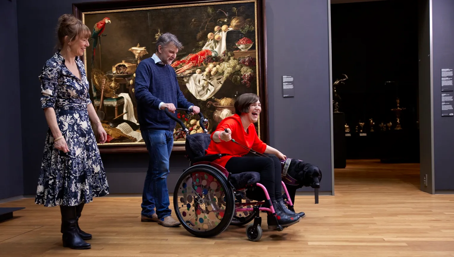 Happy woman in a wheelchair and a dog, visiting Rijksmuseum