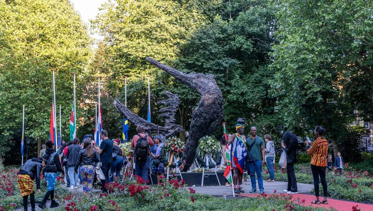 People gathering around the National Slavery Monument in the Oosterpark during Keti Koti Festival 2022.
