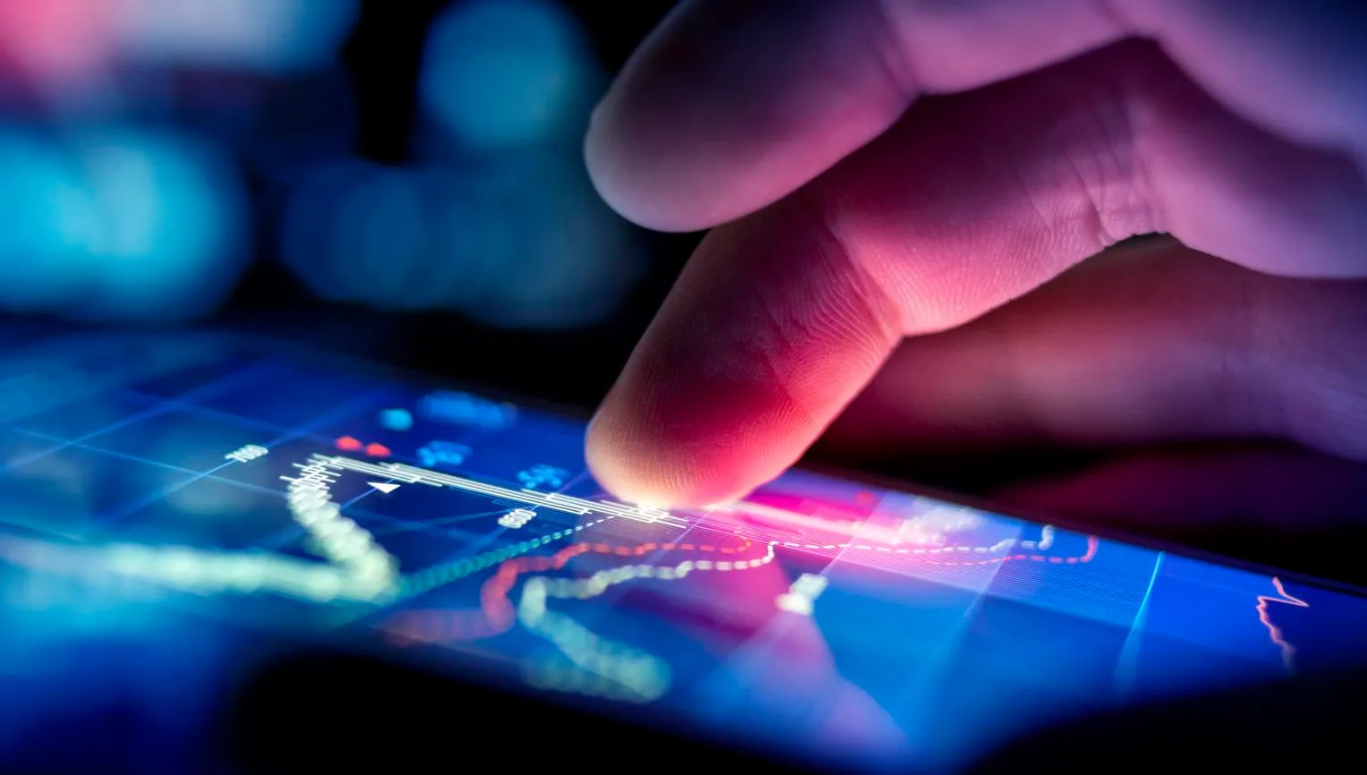 A city businessman using a mobile device to check stocks and market data. Close up shot.