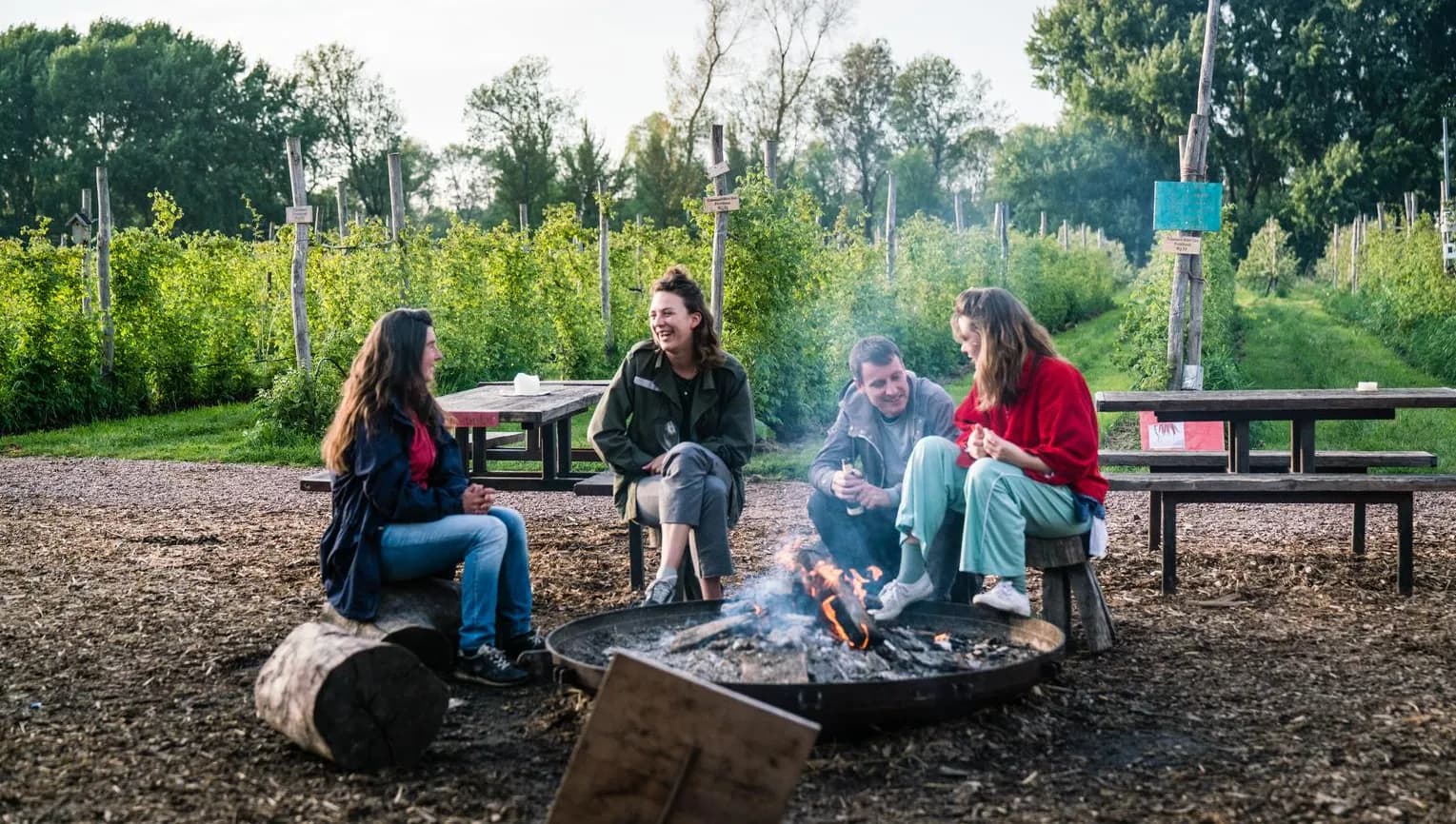 People sitting around the campfire at Fruittuin van West.