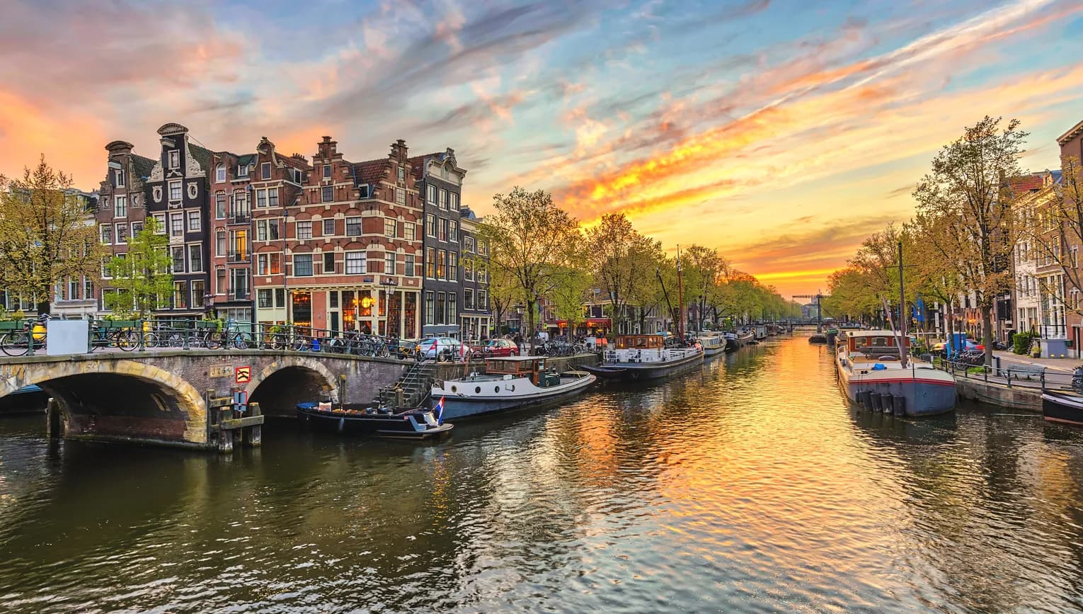 De Jordaan sunset and city skyline at canal waterfront.