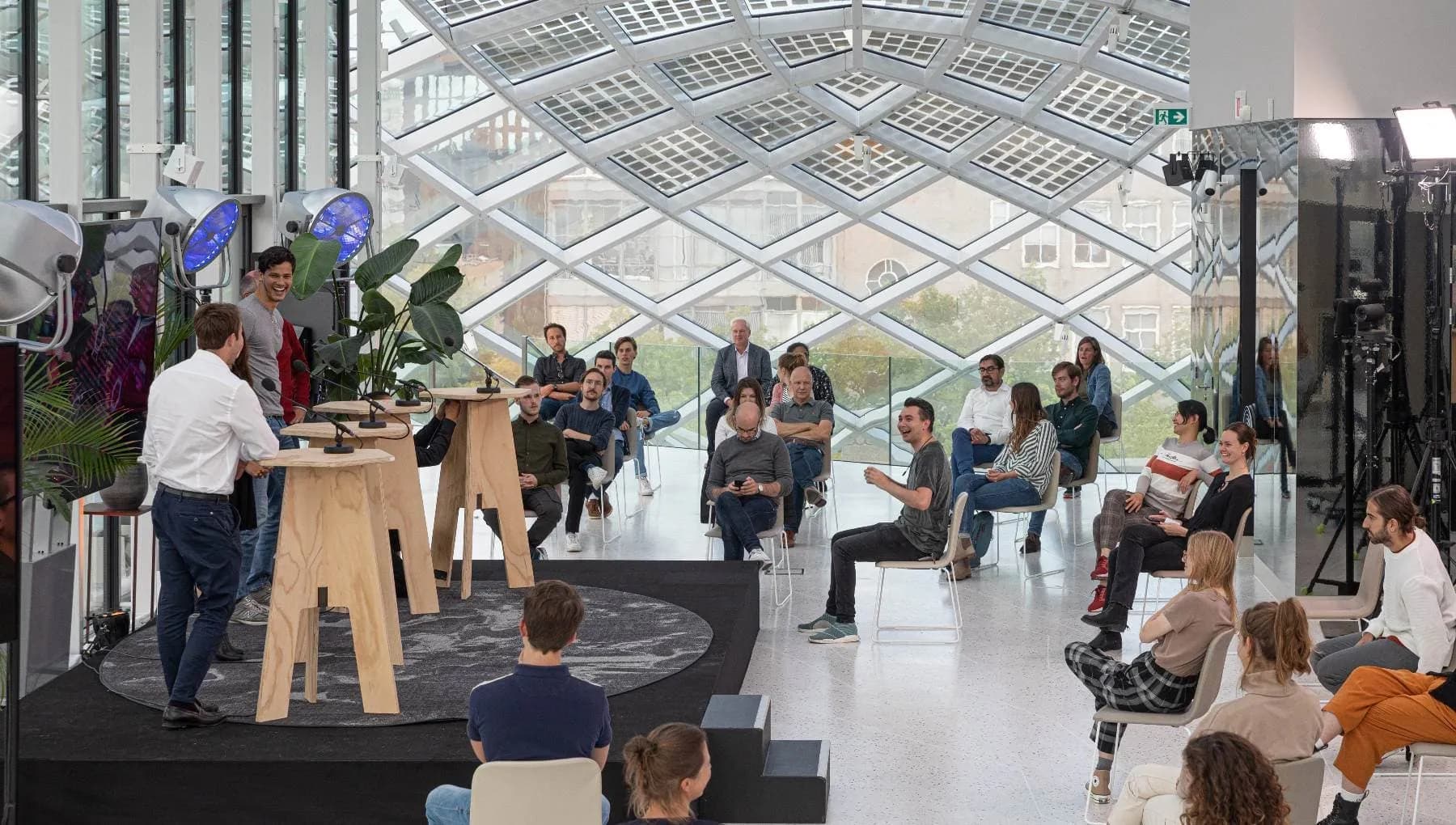 A hybrid event taking place at Capital C hotel in Amsterdam, with a stage and socially distanced audience members.