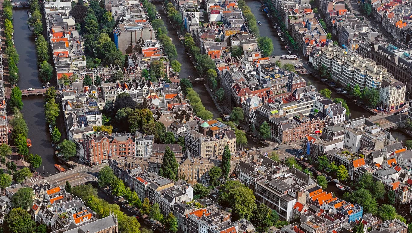 In het stedenbouwkundig concept liggen de grachten bijna evenwijdig aan elkaar. De grachtengordel is een systeem van straten, kades, bruggen en woonhuizen. Veel grachtenpanden zijn van de 18e eeuw en hebben veel verschillende architectuurstijlen. Architect Jacob Otten Husly ontwierp het voormalige kunst en wetenschap centrum aan de Keizersgracht dat in 1788 geopend werd. De grachtengordel West heeft veel historische gebouwen uit de zestiende eeuw en is onderdeel van de binnenstad van Amsterdam. Foto John Gundlach