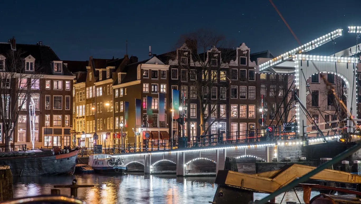 Scenic view of Amsterdam city and the river Amstel bridge at night (it's the Magere brug)