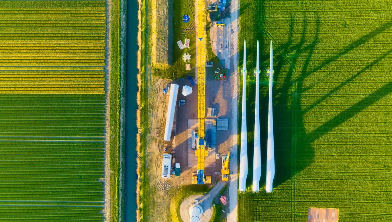 Construction and installation of a wind turbine. Production of clean green energy. Technology and innovation. Aerial view. Industrial landscape from a drone. Top view.