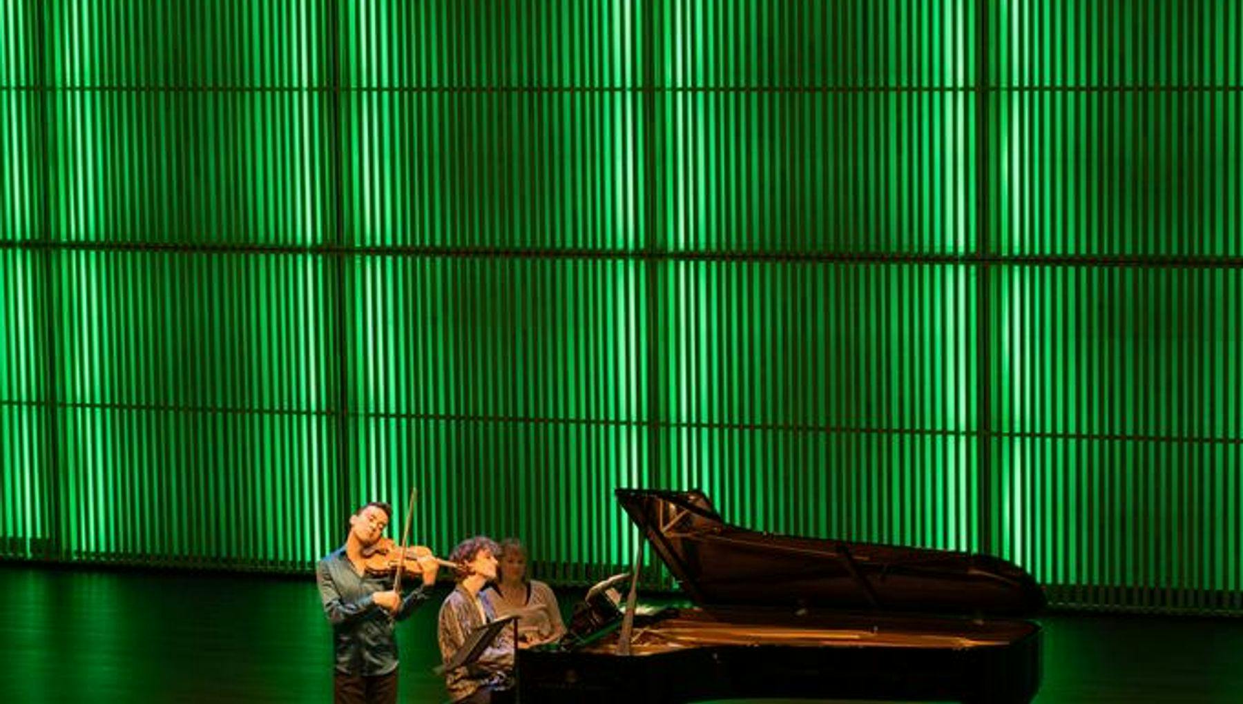 A violinist and a pianist on stage in het Muziekgebouw aan 't IJ