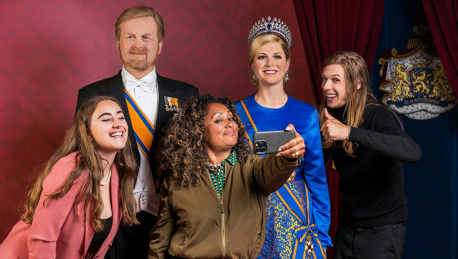 Madame Tussauds women posing with the Dutch King & Queen