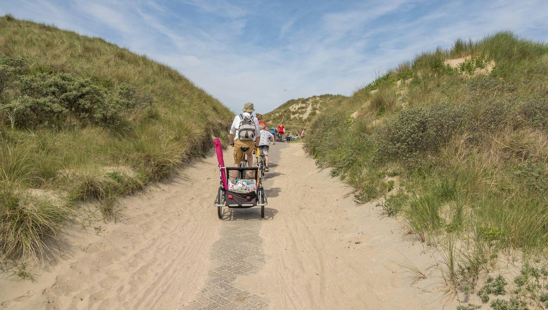 Family cycling through the dunes of Heemskerk Beach