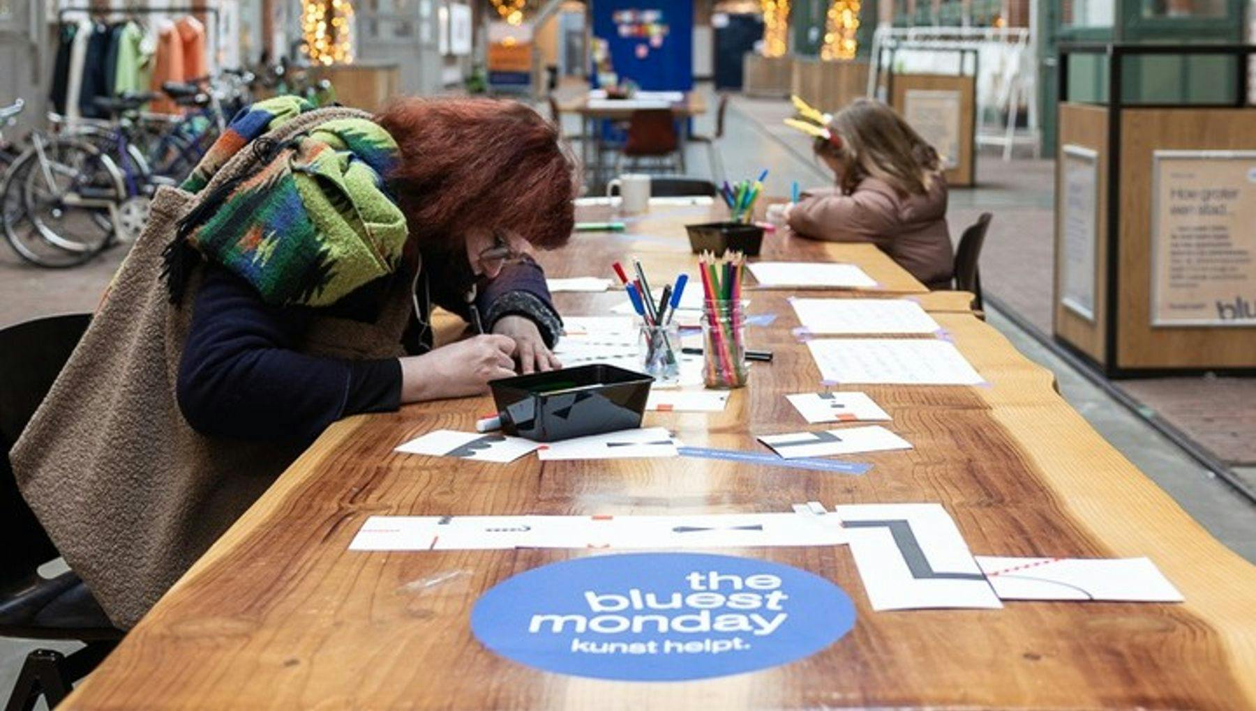 People writing on The Bluest Monday table