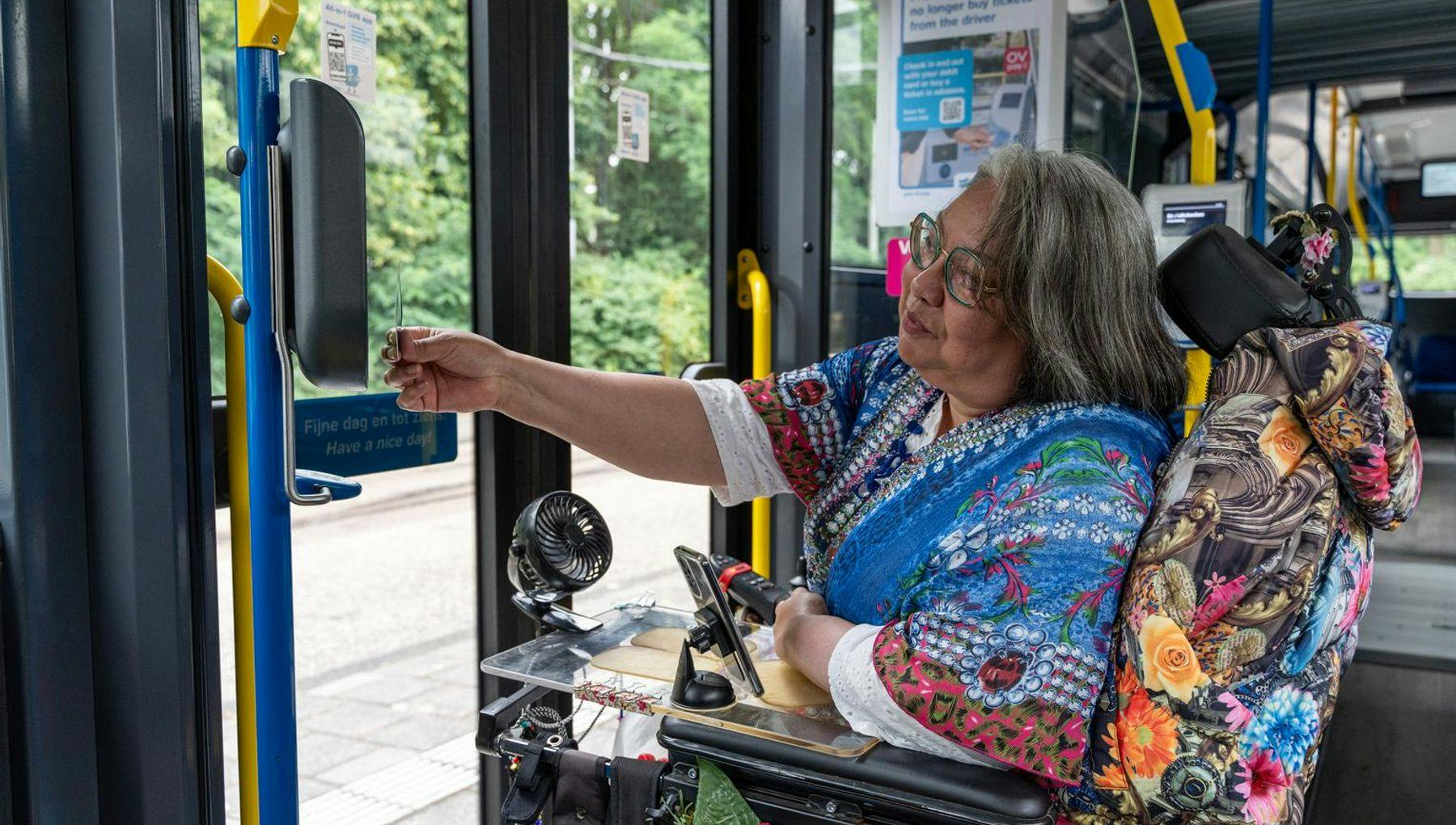 A person in an electric wheelchair in a bus checking-out.