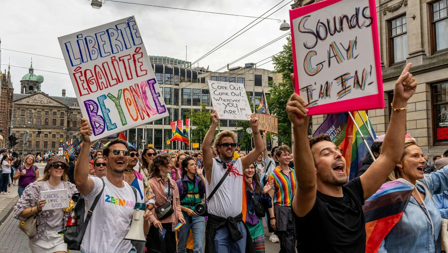 People carry signs during Queer Walk 2023.