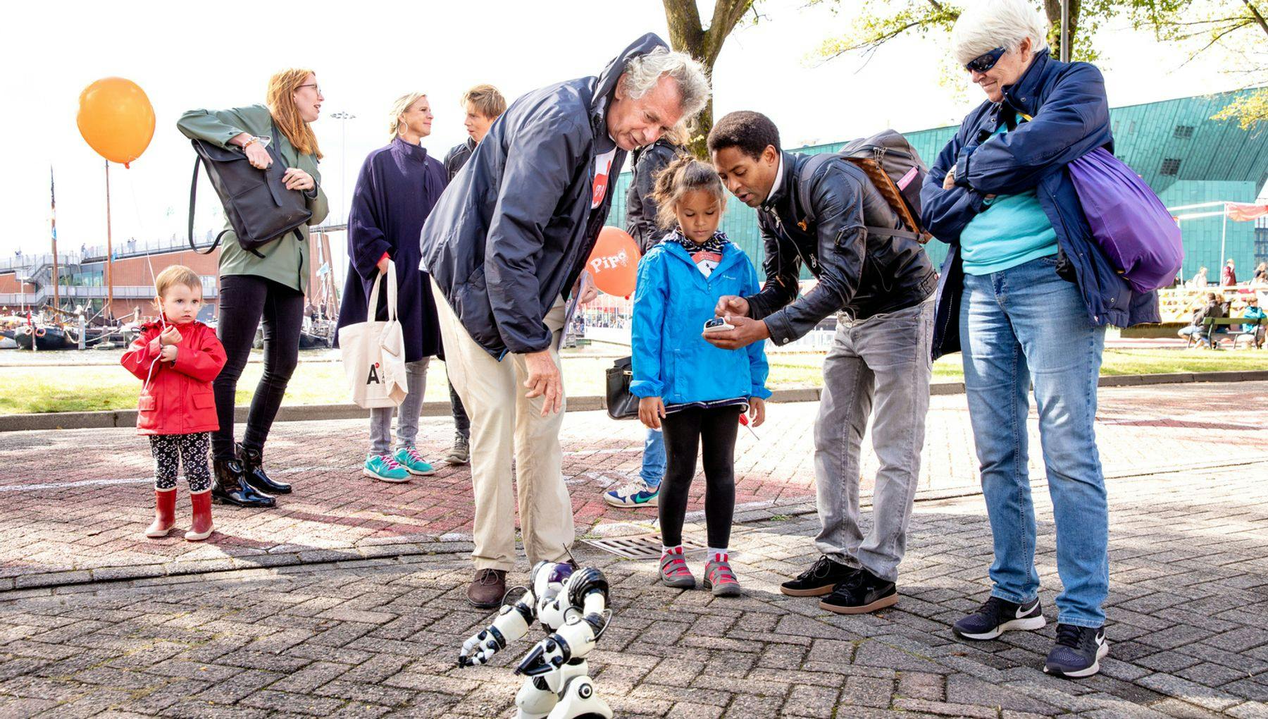 A man teaching a child how to control an electronic robot