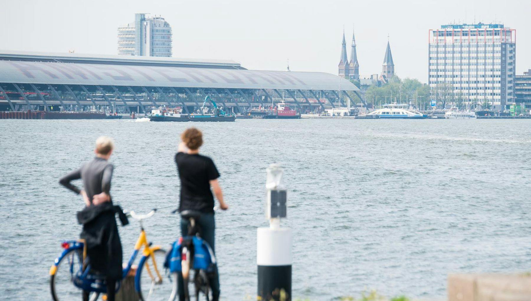 Cyclists looking over IJ River towards Centraal Station