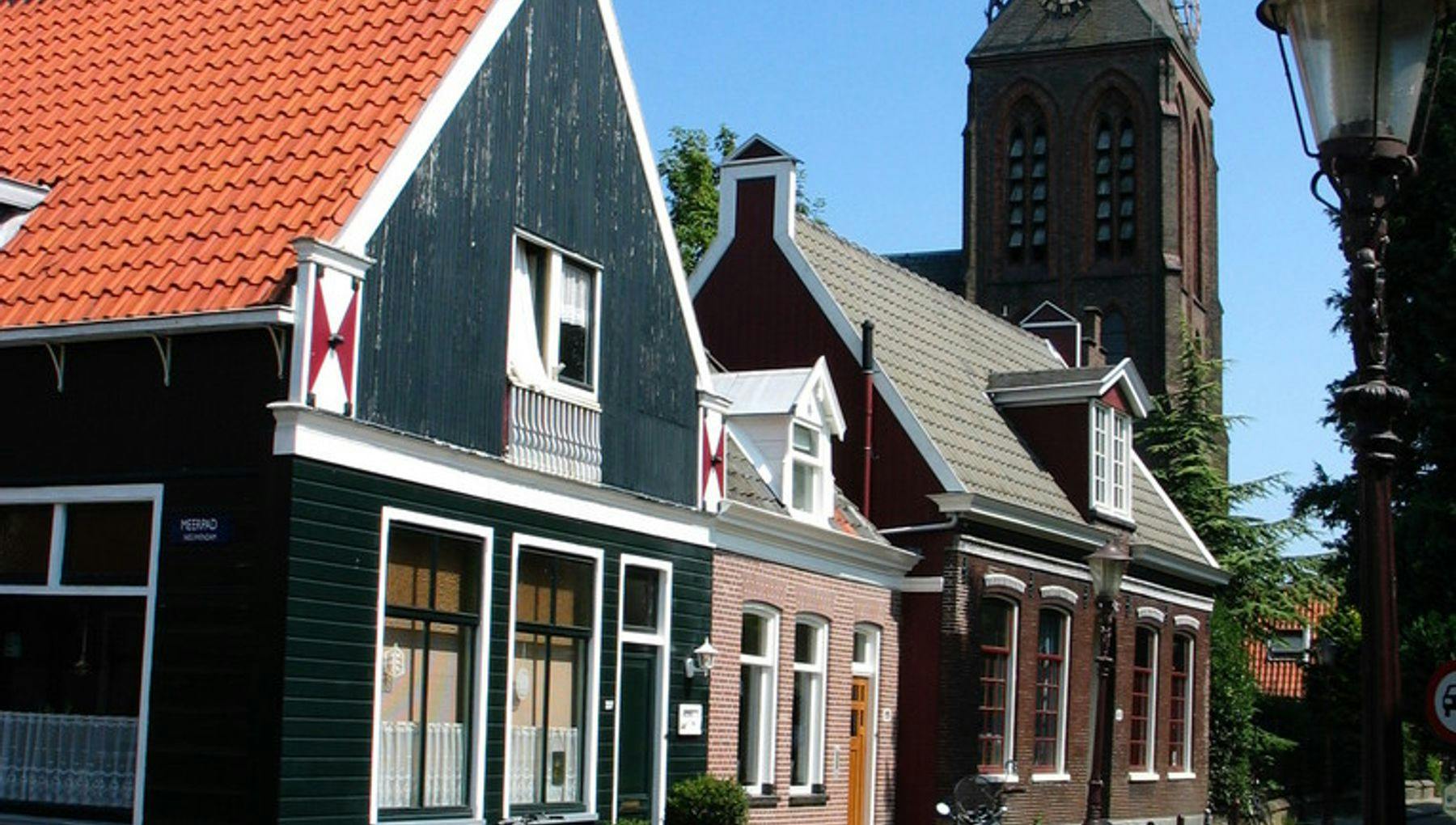 A view of a street in Durgerdammerdijk with traditional houses in sunny weather