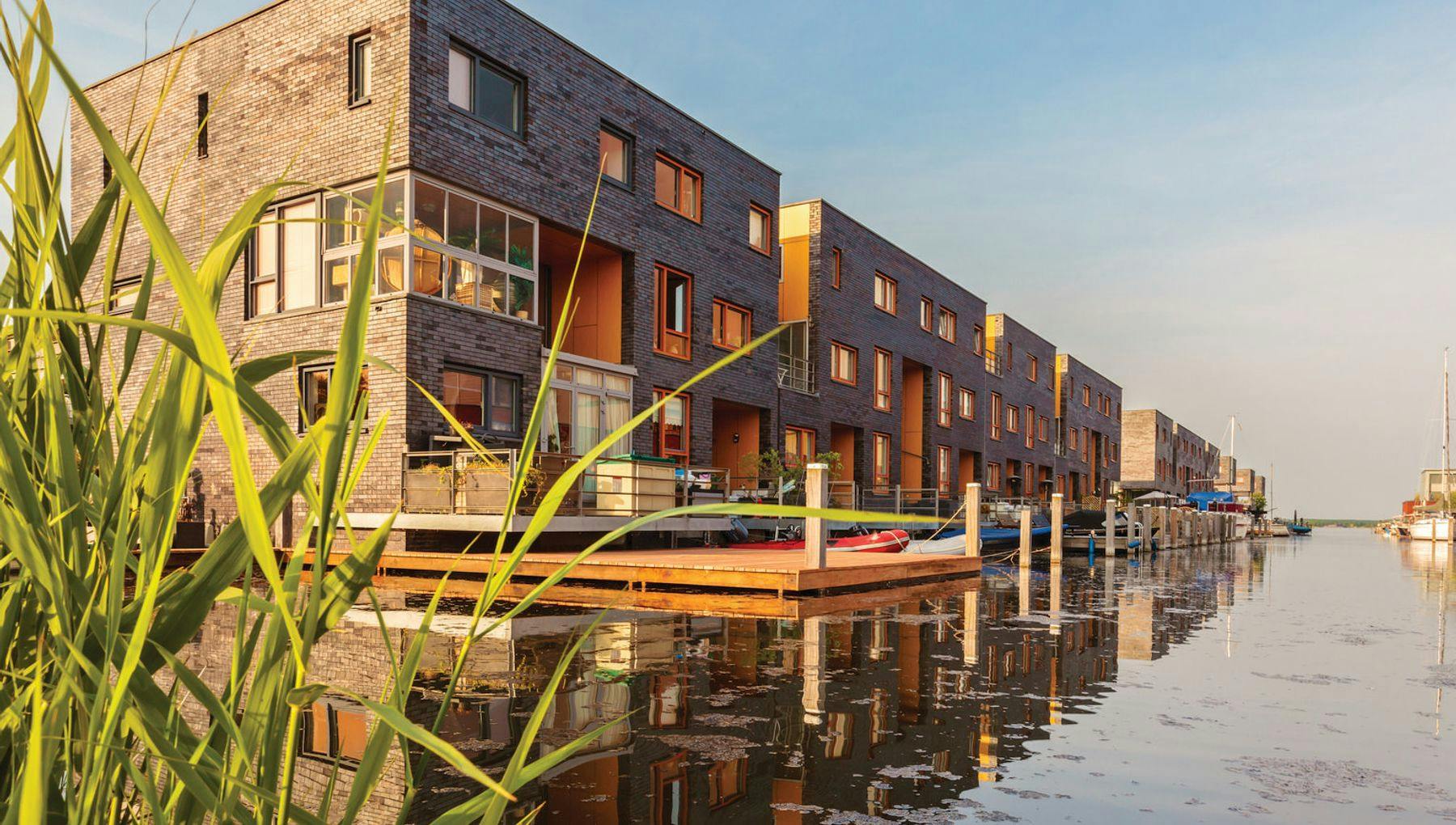Row of Dutch modern canal houses in Almere reflected in the water