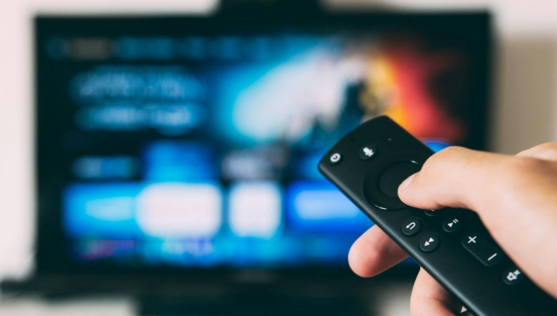 Hand with remote pointing at tv, Unsplash stockphoto
