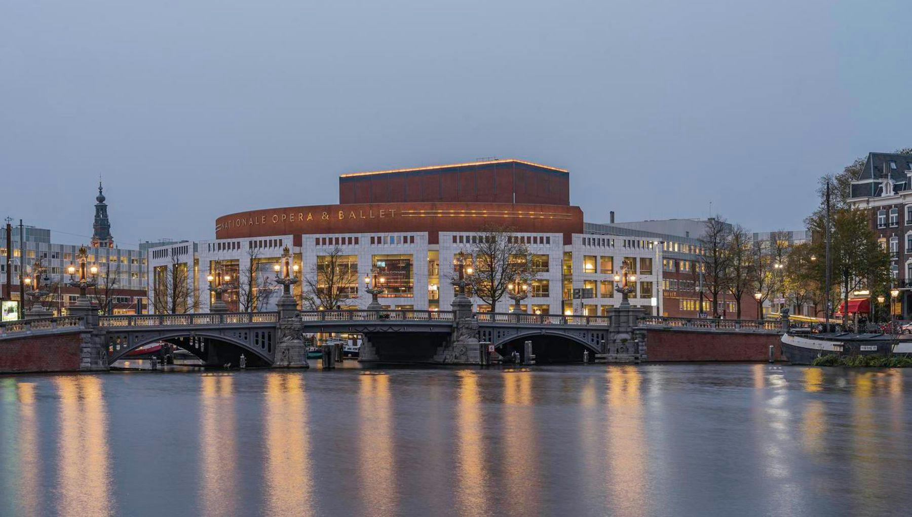 The National Opera & Ballet at nightfall, seen from a distance. This cultural institution is located at the Amstel river, close to Waterlooplein in the city centre.