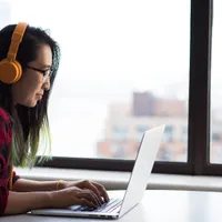 Woman working on laptop in high-rise building