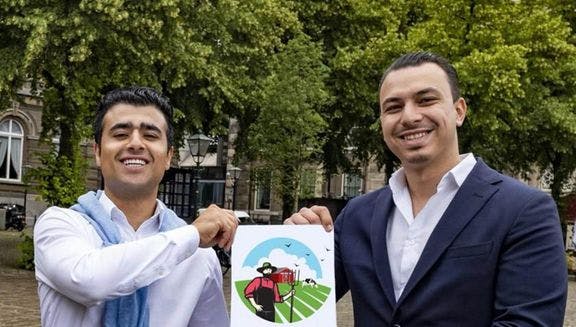 delokaleboer.nl co-founders Adam Emad and Omar Elfouli holding up their company logo and smiling.