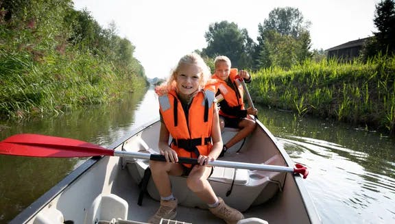 Kids canoeing in nature park De Kemphaan.