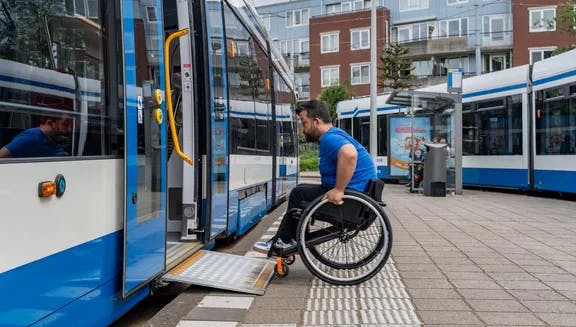 A person in a wheelchair taking the tram.
