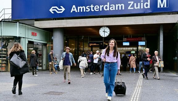 Women with suitcase in front of NS station Amsterdam Zuid