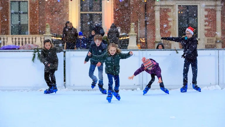 Children are ice skating at Zaanse Dickens christmas market.