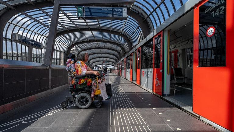 A person in an electric wheelchair enters the metro.