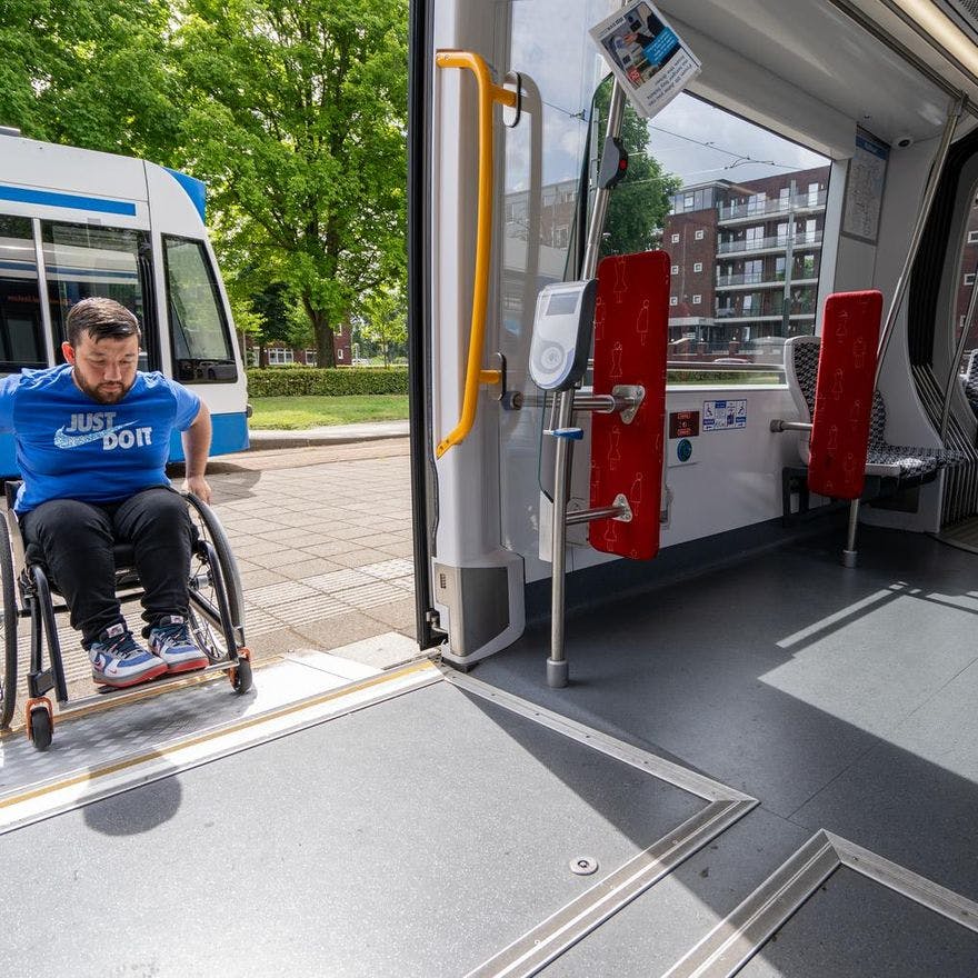 A person in a wheelchair taking the tram.