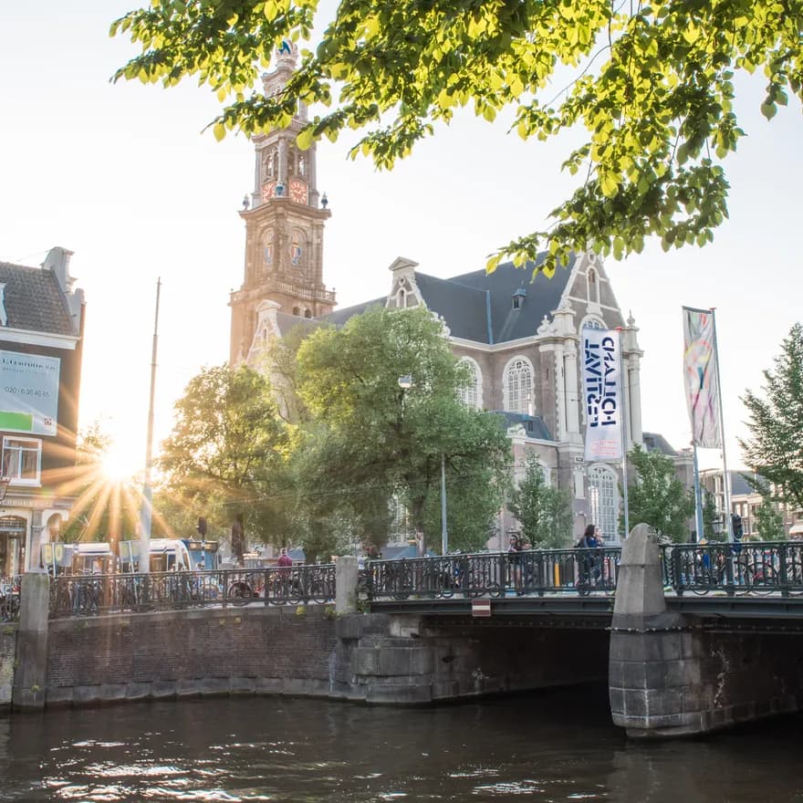 Foto van de Westertoren met brug op de voorgrond.