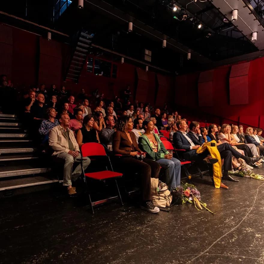 Theater De Landing, theater in Schouwburg Amstelveen, interior people sitting in the crowd on red chairs