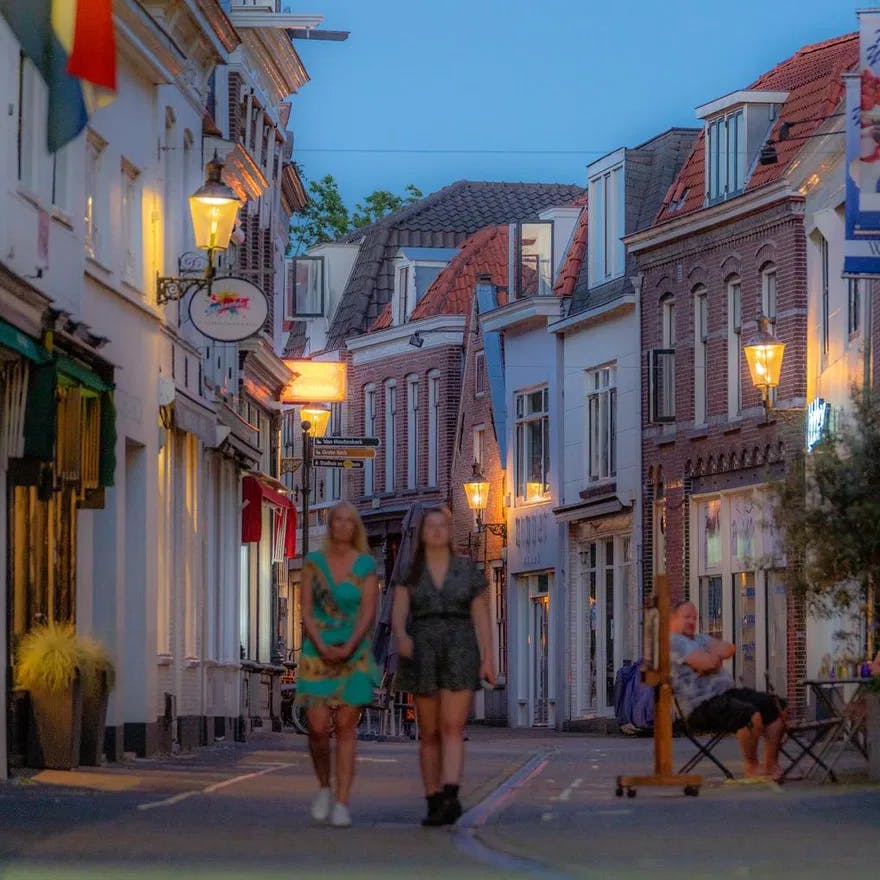 People walking through the streets of Weesp at night