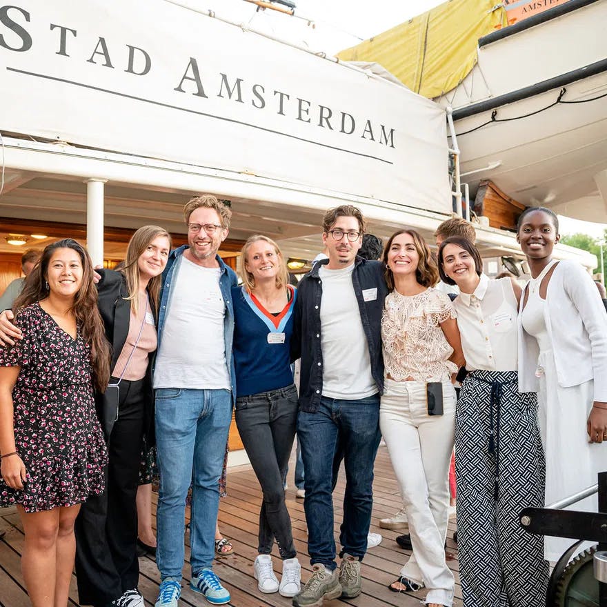 Photograph of StartupAmsterdam team having summer drinks, with "Stad Amsterdam" sign in background.