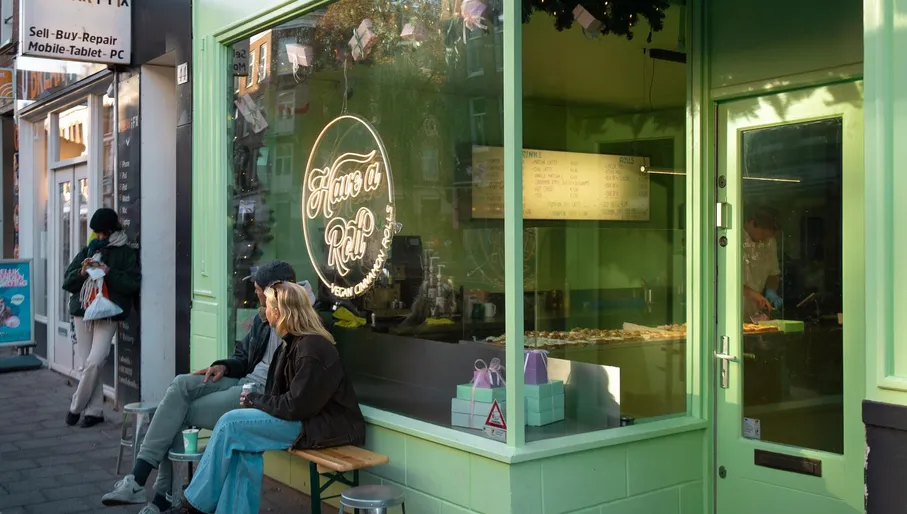 Couple sitting in the sun outside Have a Roll bakery on Van Woustraat in De Pijp