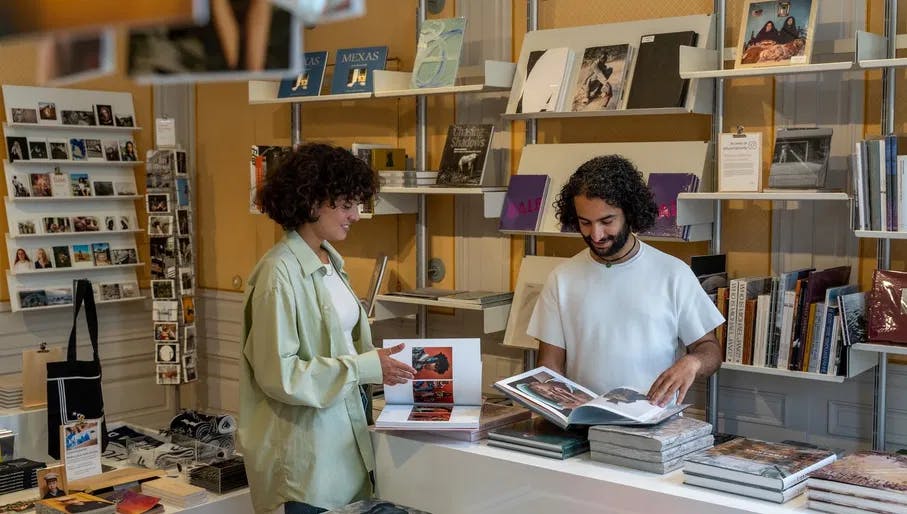 A couple checks out the books of the museum shop of Huis Marseille.