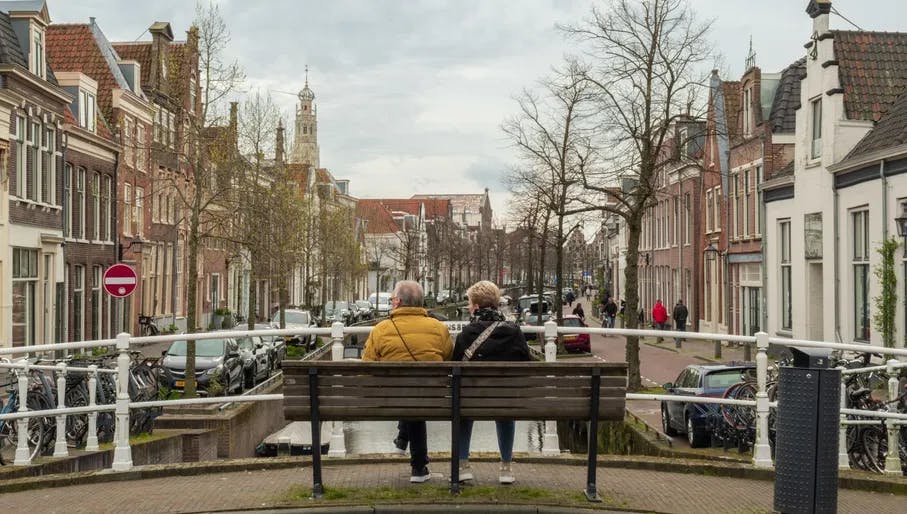 Old couple sitting on a bench on a bridge in Haarlem watching the canal. Haarlem Content Creation Day March 2024