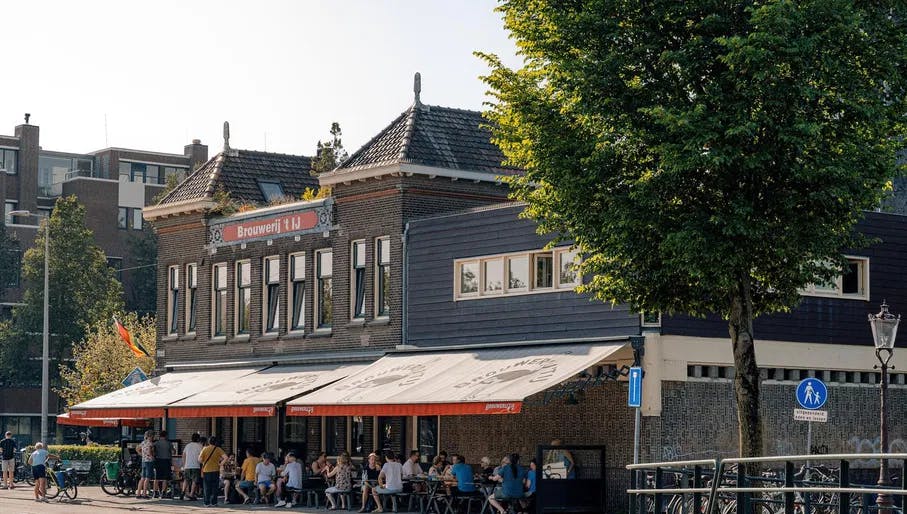 People sitting on the terrace outside Brouwerij 't IJ. Instawalk Oostelijke Eilanden september 2023 people on a terrace