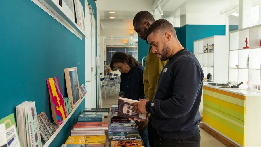 People looking at books in the museum store of CBK Zuidoost.
