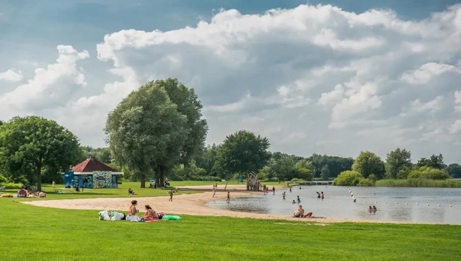 People sitting and swimming at Gaasperplas.