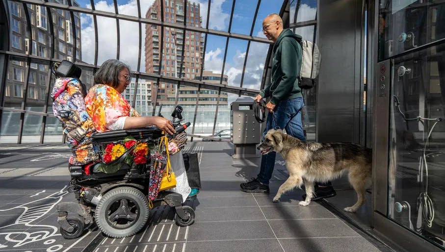 A person in an electric wheelchair on the metro platform waiting before entering the elevator in Noord.