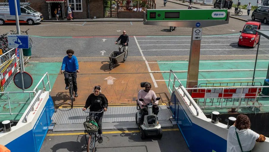 A person in an electric wheelchair taking the ferry at IJplein.