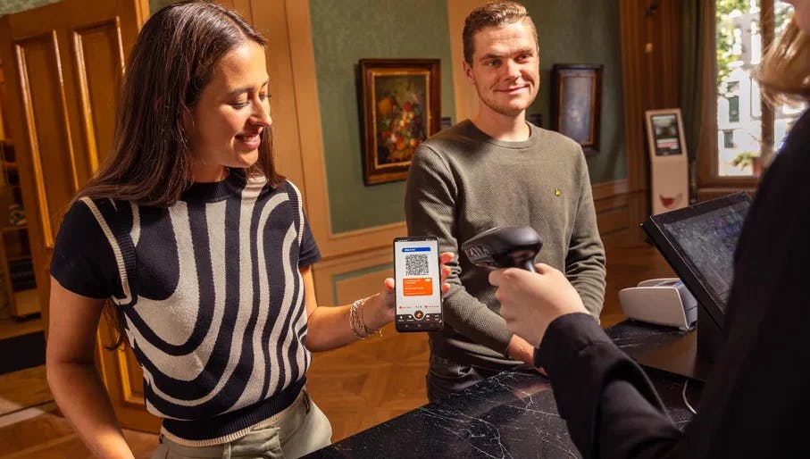 A couple checks-in at the museum desk with the digital City Card app.